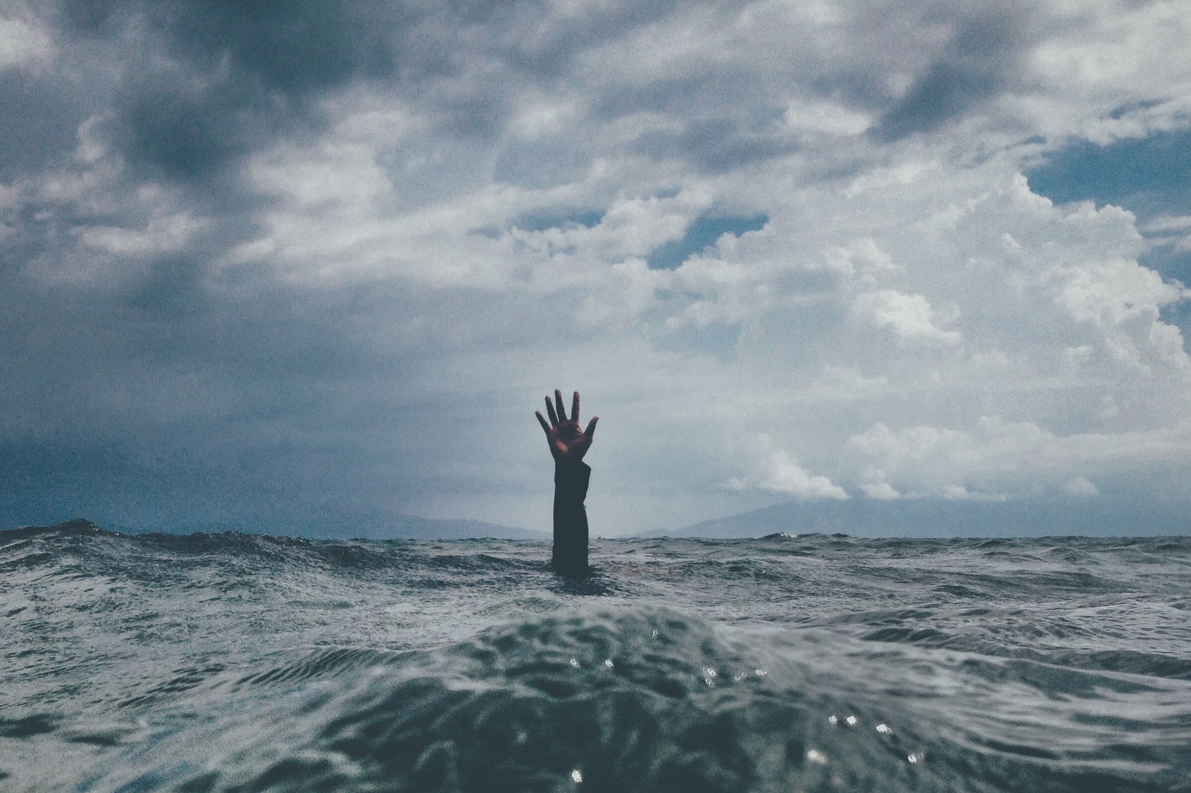 Hand coming out of the water in search for help. Image for mental health article post covid